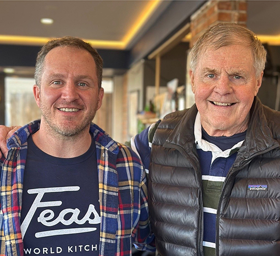 Aizley Hansen and her group in Tanzania sitting on rocks in front of a waterfall.