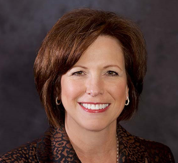 Une femme assise sur un tabouret à côté d’un pupitre